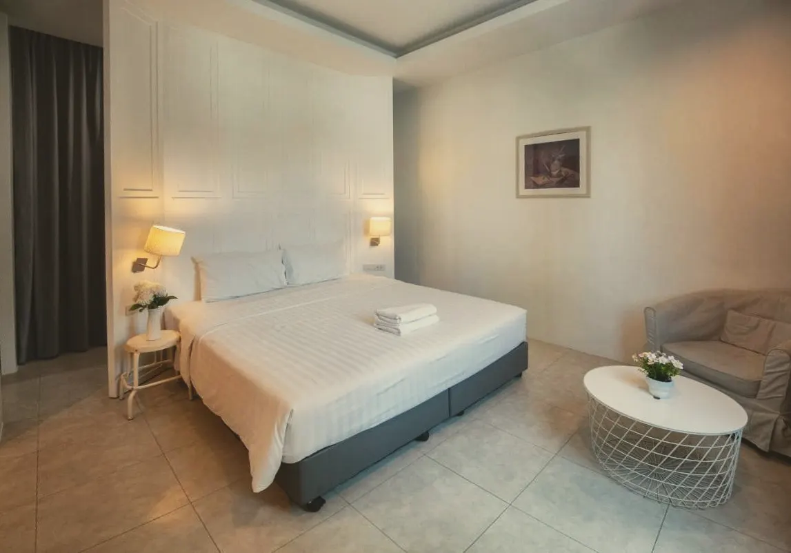 Grand Deluxe Family room with a large bed, armchair and side table